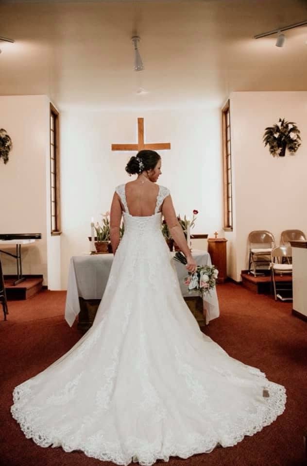 Bride In A Lace Wedding Gown Stands At The Altar
